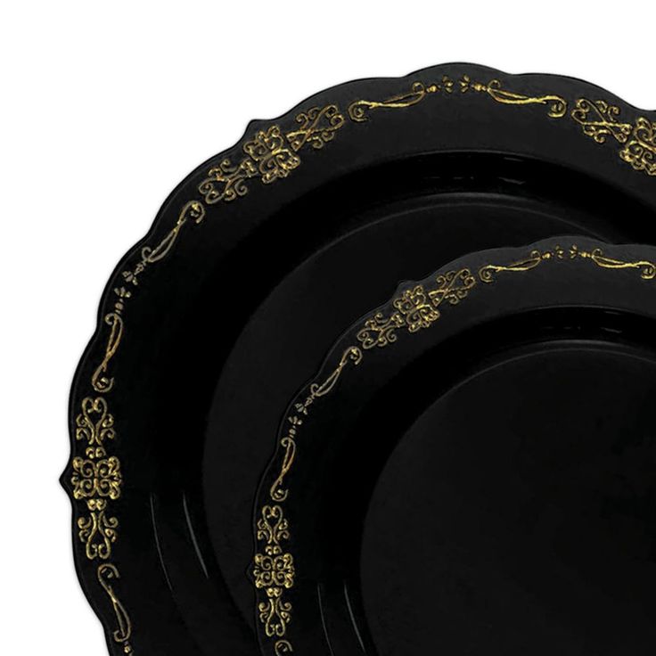 four black and gold dinner plates on a white background