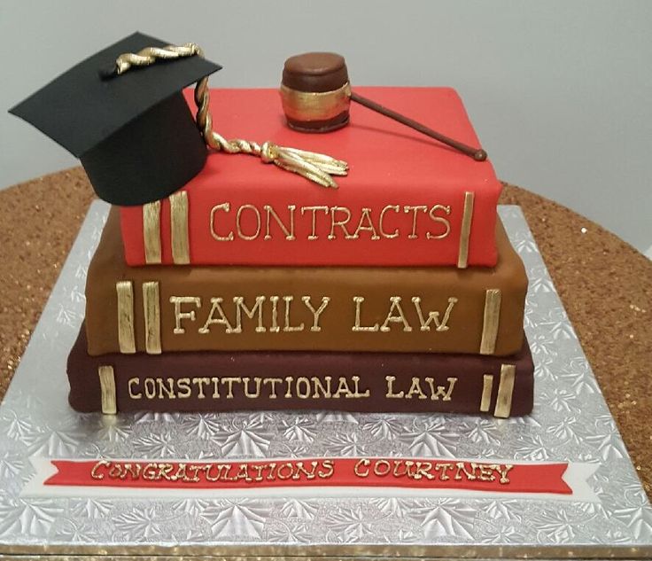 a cake made to look like two books with graduation caps and diplomas on top