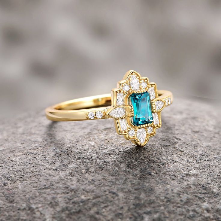 Step into the elegance of a bygone era with our Natural London Blue Topaz Ring, beautifully set in 14K yellow gold vermeil. This exquisite engagement ring draws inspiration from the opulent Art Deco period, blending vintage charm with timeless sophistication.►The centerpiece is a stunning London blue topaz, renowned for its deep, captivating hue that evokes the mysterious beauty of twilight skies. The intricate detailing of the band, adorned with delicate filigree patterns and sparkling accents, Timeless Gold Emerald Ring For Wedding, Gold Emerald Wedding Ring, Timeless Style, Elegant 14k Gold Topaz Ring With 17 Jewels, Timeless Gold Topaz Ring For Anniversary, Elegant 14k Gold Topaz Birthstone Ring, Elegant Emerald Cut Topaz Ring With 17 Jewels, Art Deco 14k Gold Emerald Ring, Elegant Emerald Cut Topaz Ring, Heirloom Gold Topaz Ring With Accent Stones