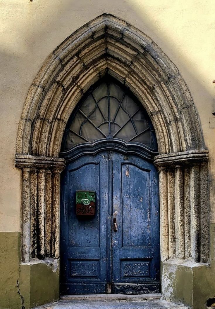 an arched doorway with a blue wooden door