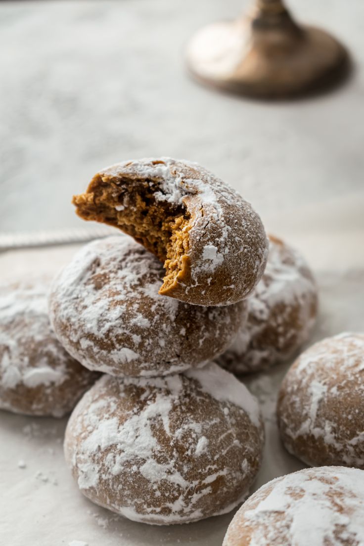 powdered sugar donuts stacked on top of each other with one bite taken out