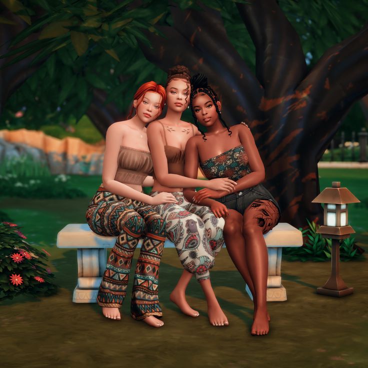 three women sitting on a bench in front of a tree