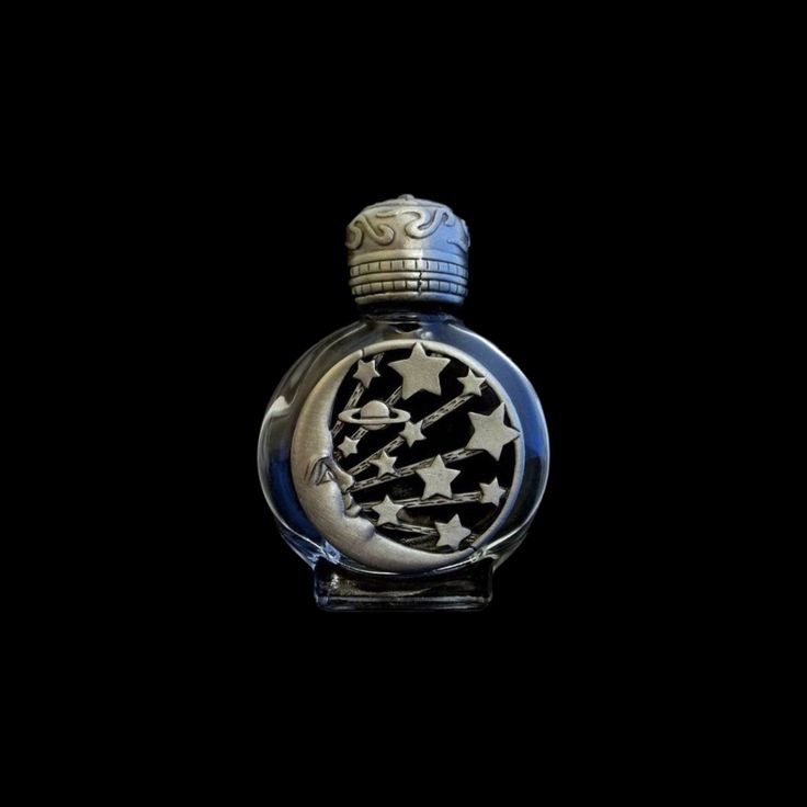 an old fashion perfume bottle with black and white designs on the front, against a dark background