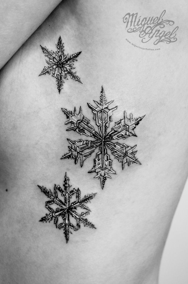 a snowflake tattoo on the back of a woman's shoulder