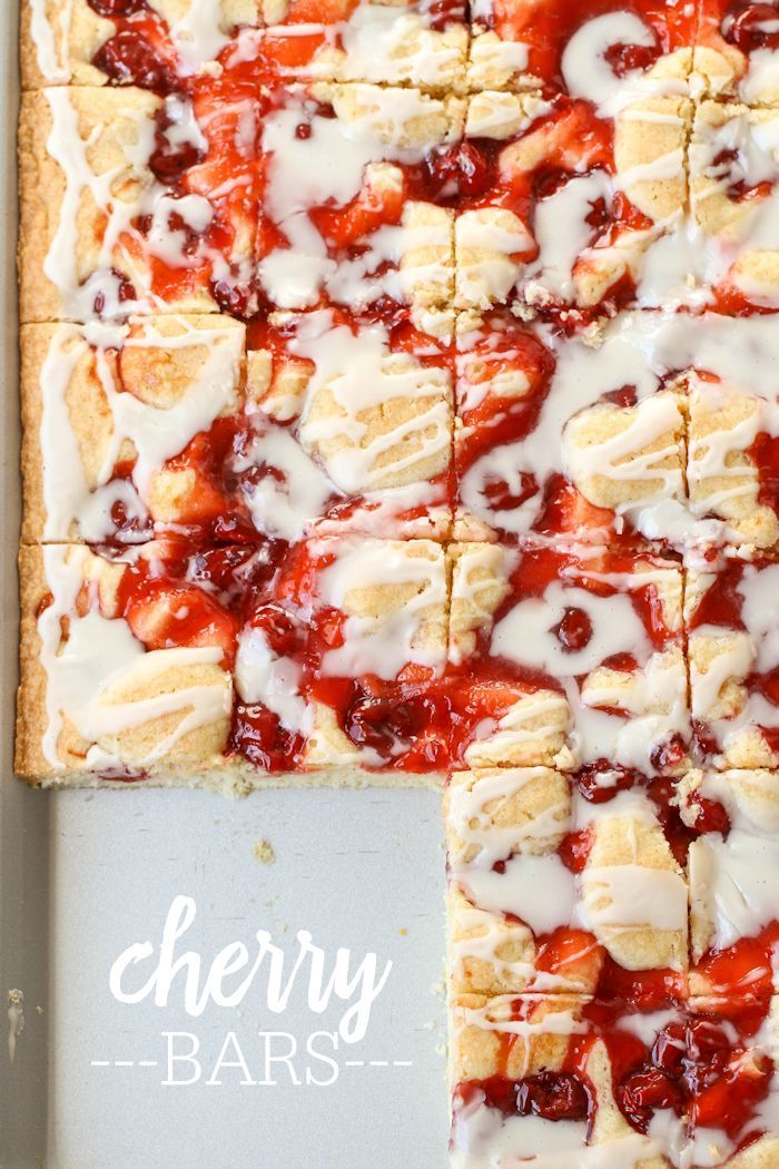 strawberry shortbread squares with icing on a baking sheet