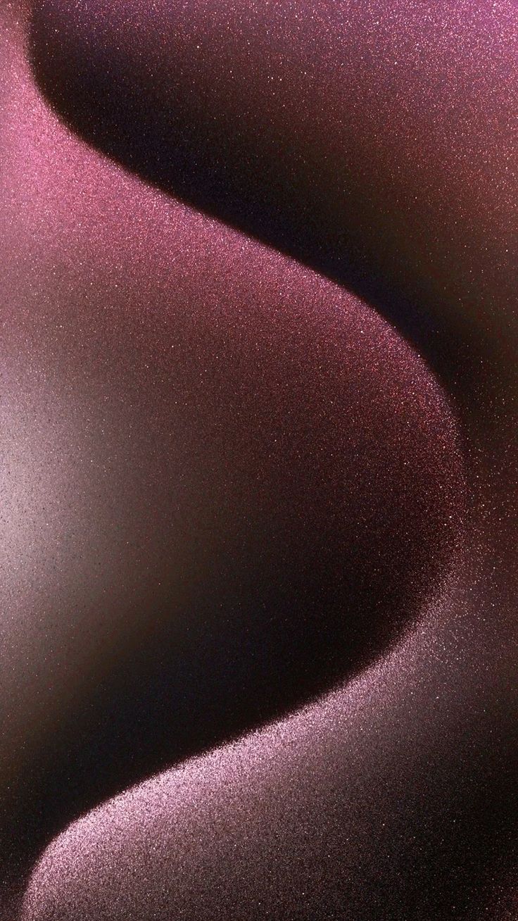 a close up view of the surface of a pink and purple material with some black spots on it