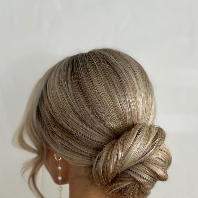 a woman with blonde hair styled into a low bun