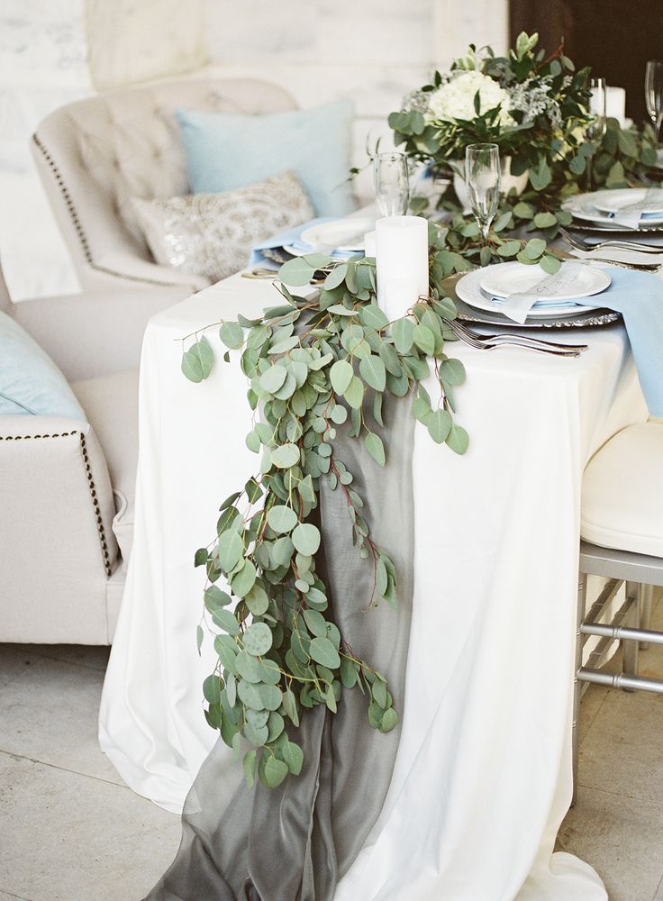 an image of a table setting with flowers and greenery on the table for a wedding reception