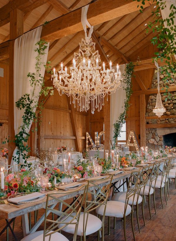 a long table is set with candles, flowers and greenery for an elegant wedding reception