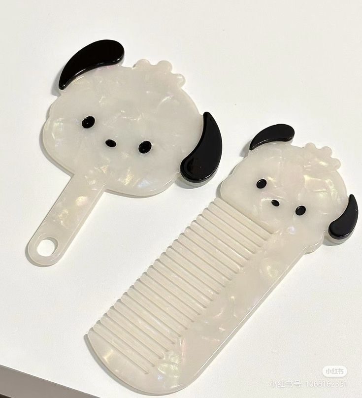 two panda bear combs sitting next to each other on a white counter top,