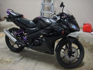 a black motorcycle parked in a garage next to a ladder