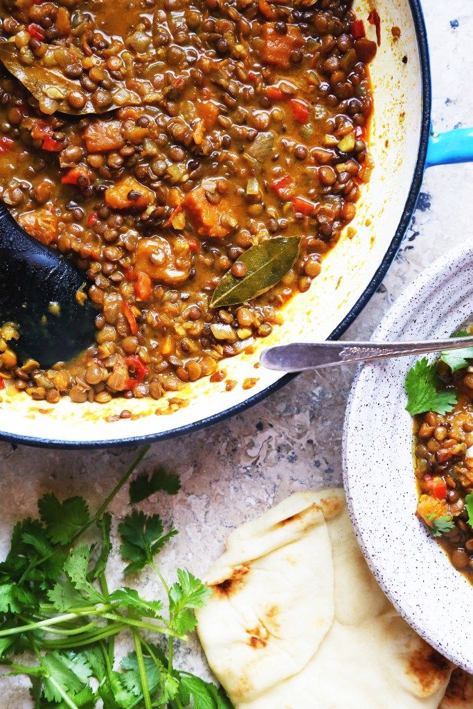 a pot filled with lentils next to tortillas