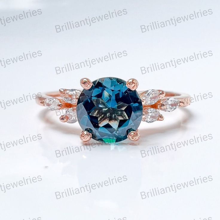 an oval blue and white diamond ring with three stone accents on the band, set in 18k rose gold