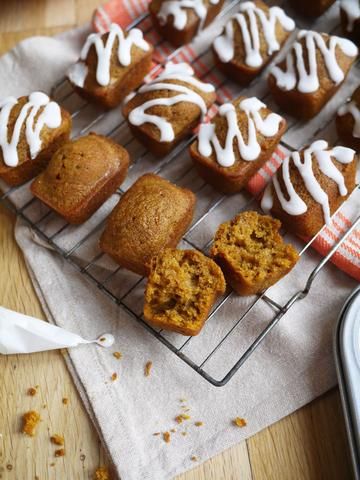 several muffins cooling on a rack with icing