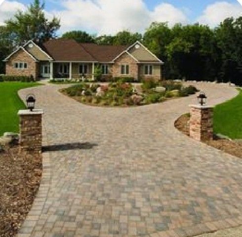 a brick driveway leading to a large house