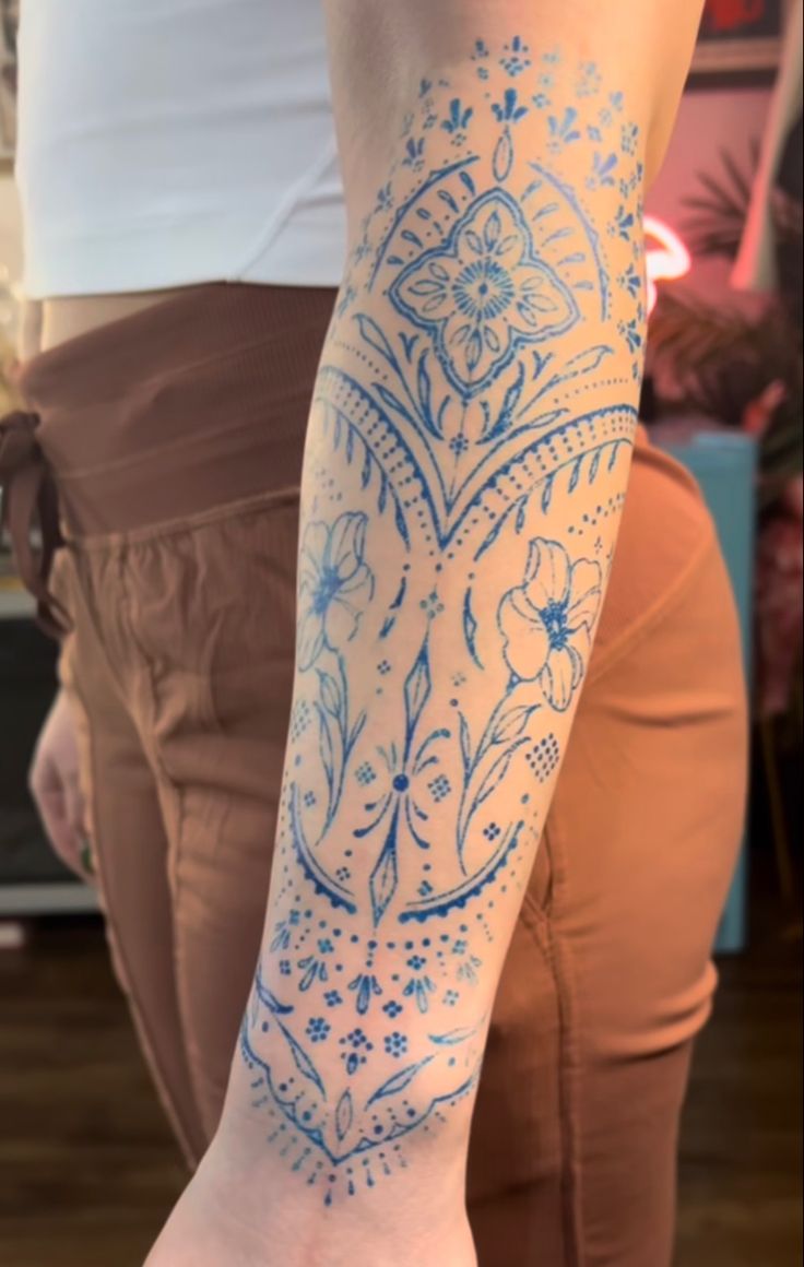 a woman with a tattoo on her arm and leg is holding a cell phone in her hand