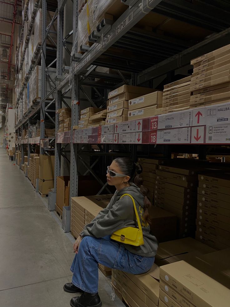 a person sitting on a shelf in a warehouse