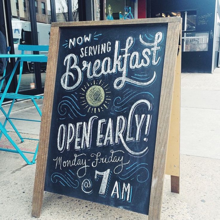 a chalkboard sign on the sidewalk advertising breakfast and open early monday, 7 am