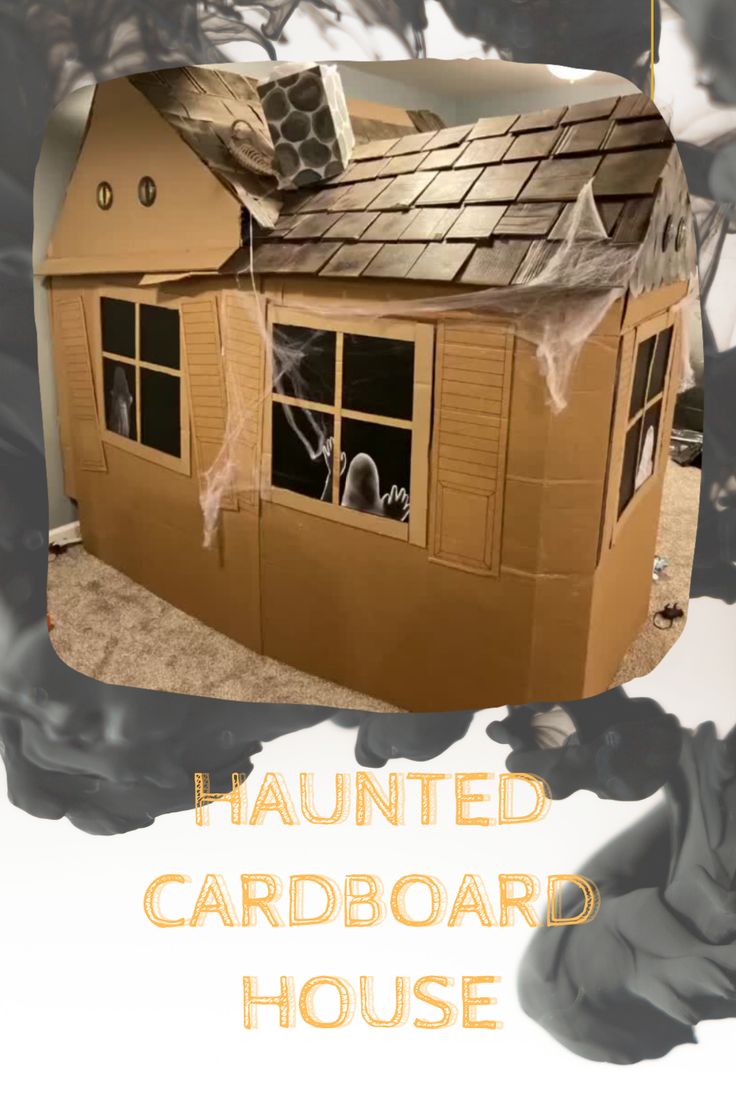 a cardboard house with spider webs on the roof