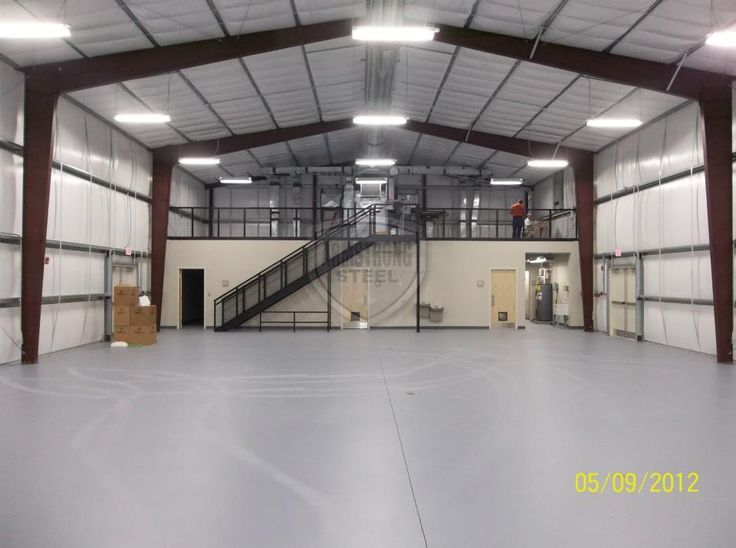 an empty warehouse with stairs and lights