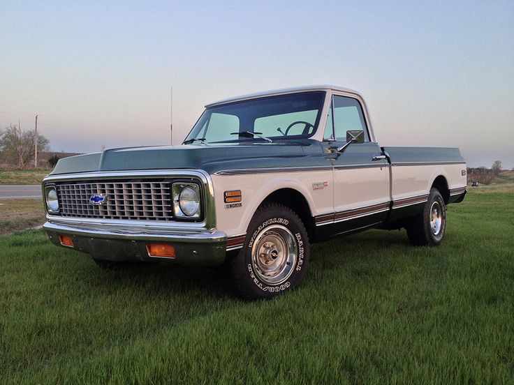 an old pickup truck is parked in the grass