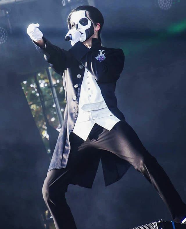 a man in a suit and mask on stage