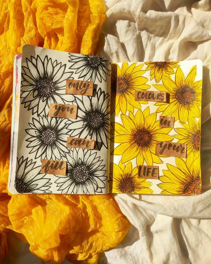 two notebooks with sunflowers on them sitting next to each other and the words i love you written in small letters