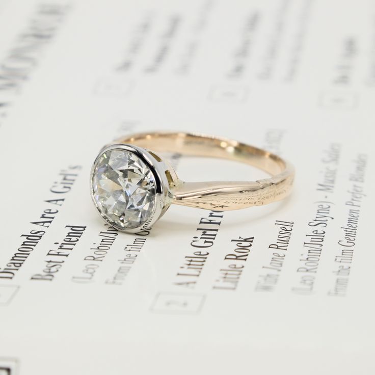 an engagement ring sitting on top of a piece of paper