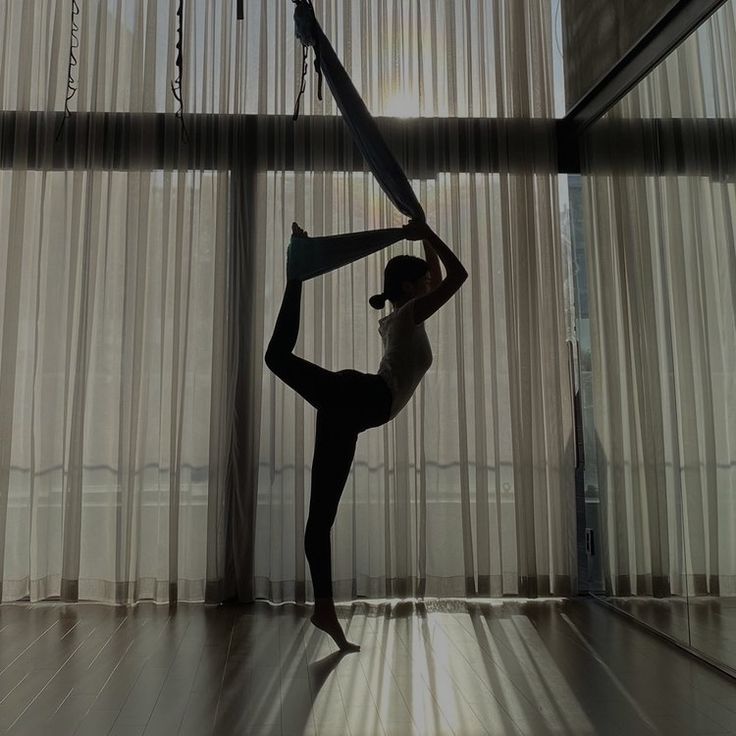 a woman doing yoga in front of a window