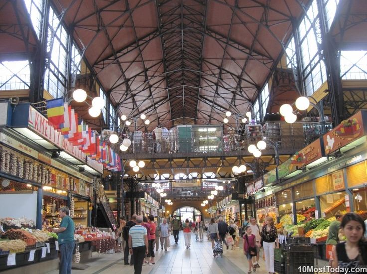 an indoor market with lots of people walking around