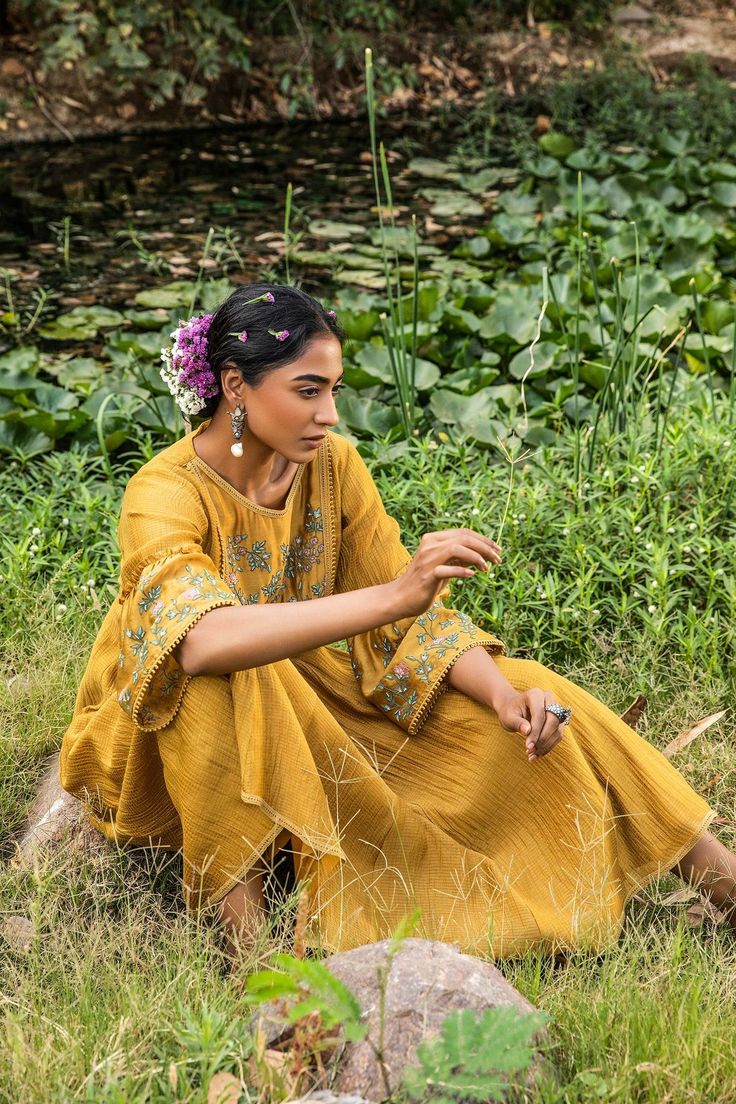 Yellow kota chanderi kurta with dori thread floral embroidery. Paired with pant.
Component: 2
Pattern: Embroidered
Type Of Work: Floral Motifs
Neckline: Round
Sleeve Type: Three Quarter
Fabric: Kurta: Kota Chanderi, Pant: Cotton
Color: Yellow
Other Details: 
Frill detail on sleeves
Front gathers on kurta
Note: The outfit worn by the other model on the back is not for sale
Occasion: Mehendi and Haldi - Aza Fashions Yellow Kurta, Floral Motifs, Pant Set, Set For Women, Aza Fashion, Floral Motif, Sleeve Type, Floral Embroidery, Three Quarter