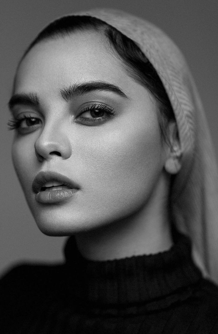 a black and white photo of a woman wearing a headscarf with her hair pulled back