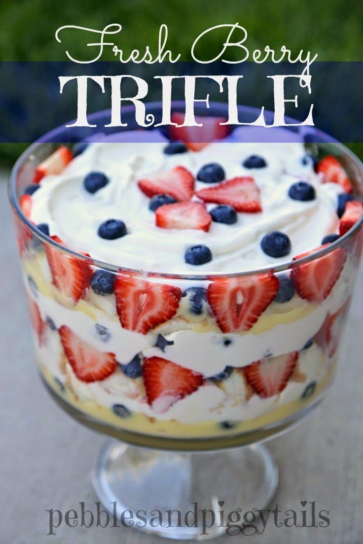 fresh berry trifle with whipped cream and blueberries in a glass dish on a table