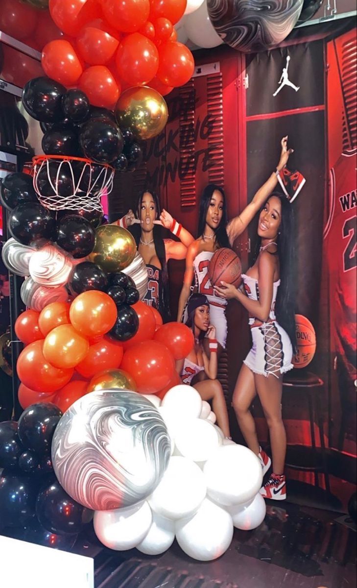 some girls are posing with basketballs and balloons