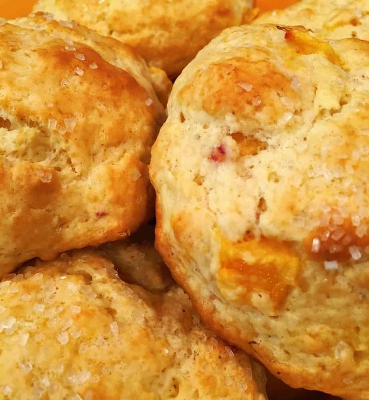 closeup of biscuits with jam on them sitting in the middle of a pile together