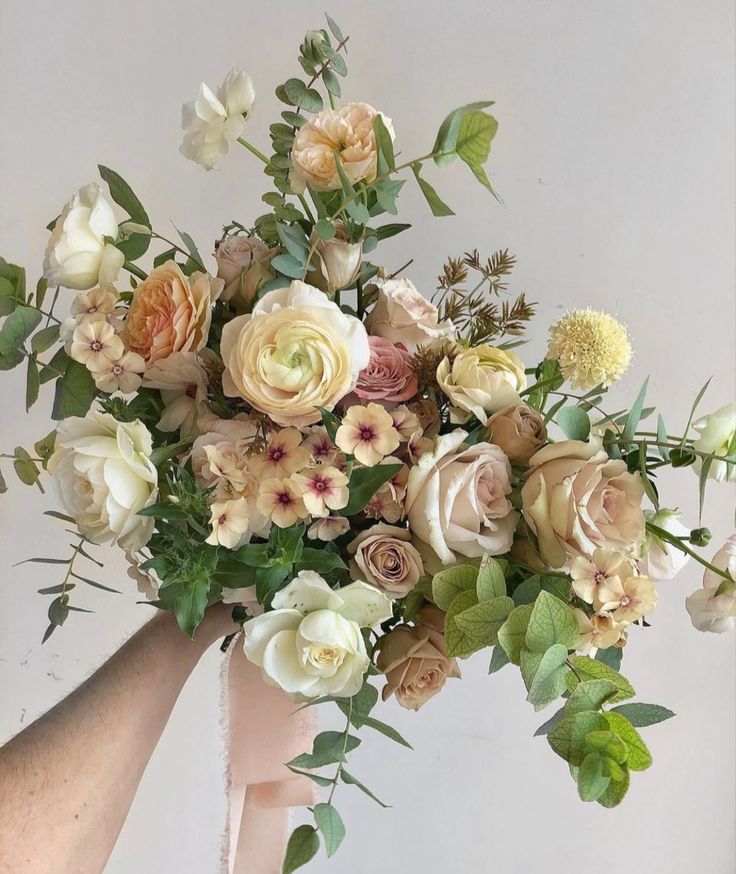 a bouquet of flowers being held by someone's hand