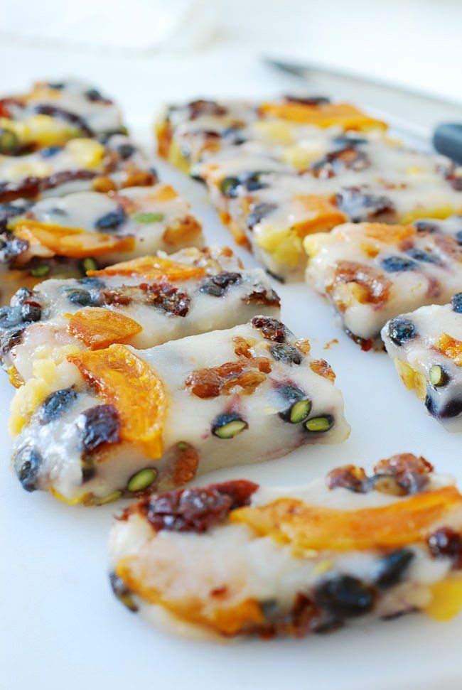 a white plate topped with slices of pizza covered in cheese and raisins next to a pair of scissors