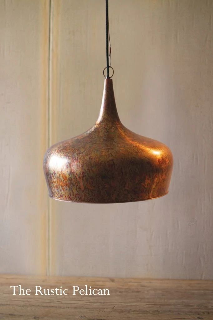 a metal light fixture hanging from a wooden table with the words rustic pelican on it