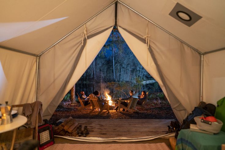 a group of people sitting around a fire in a tent