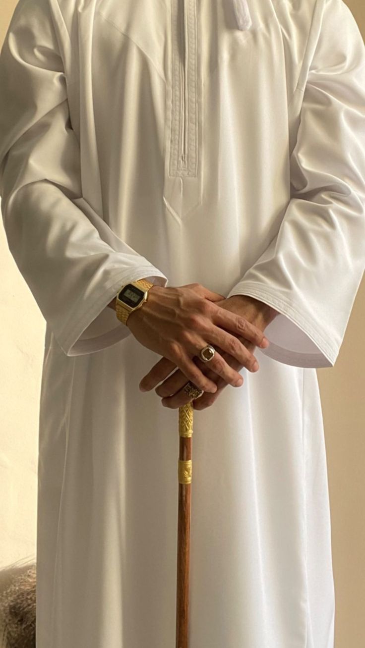 a man in white is holding a cane