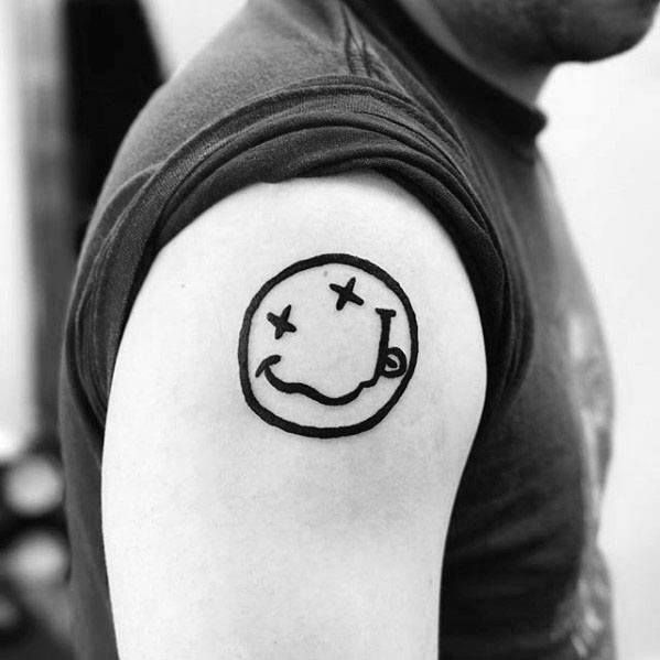 a man with a smiley face tattoo on his arm