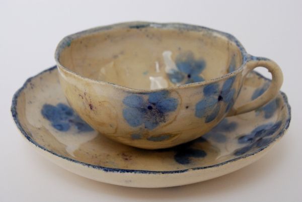 two cups and saucers with blue flowers on them