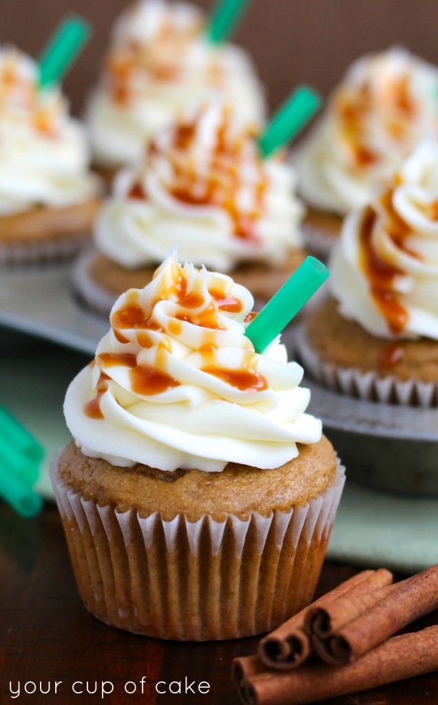 cupcakes with whipped cream and cinnamon sticks on a tray, ready to be eaten