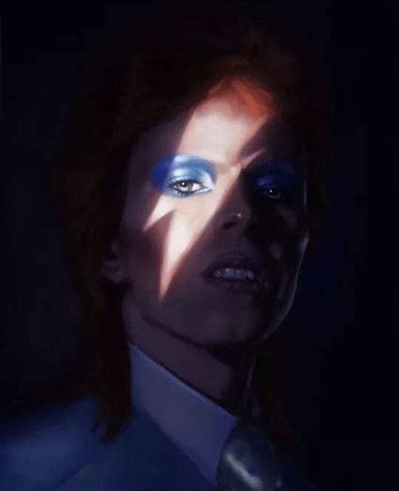 a man with blue eye makeup in the dark