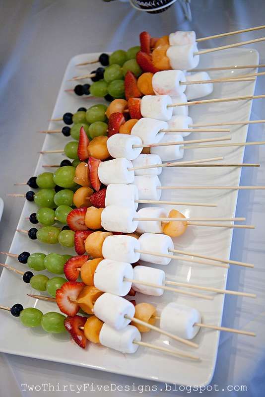 fruit skewers are arranged on a white plate