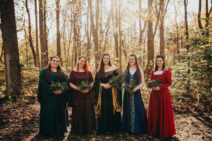 a group of women standing next to each other in the woods