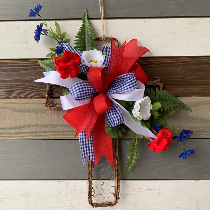 a wreath with red, white and blue flowers hanging on a wall