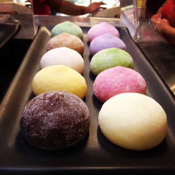 several different types of doughnuts lined up in a row on a baking tray