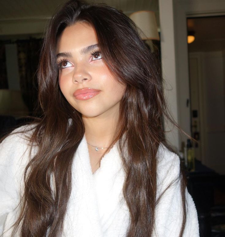 a woman with long brown hair wearing a white robe