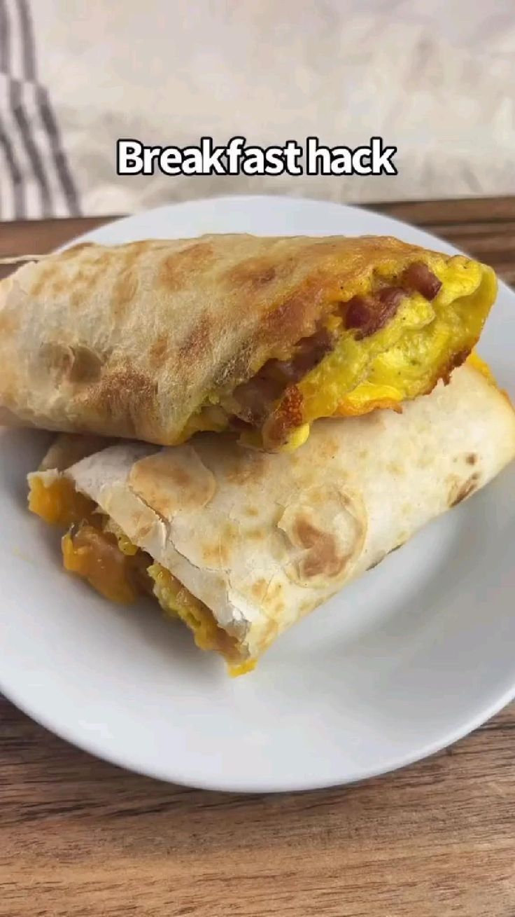 two breakfast burritos on a white plate